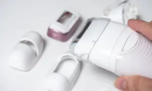 Dłoń trzyma depilator Philips Lumea, obok leżą różne nasadki. Dowiedz się, jak używać Philips Lumea.