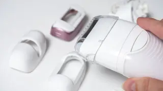 Dłoń trzyma depilator Philips Lumea, obok leżą różne nasadki. Dowiedz się, jak używać Philips Lumea.