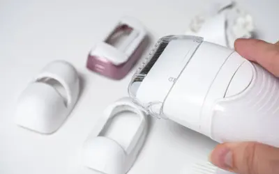 Dłoń trzyma depilator Philips Lumea, obok leżą różne nasadki. Dowiedz się, jak używać Philips Lumea.