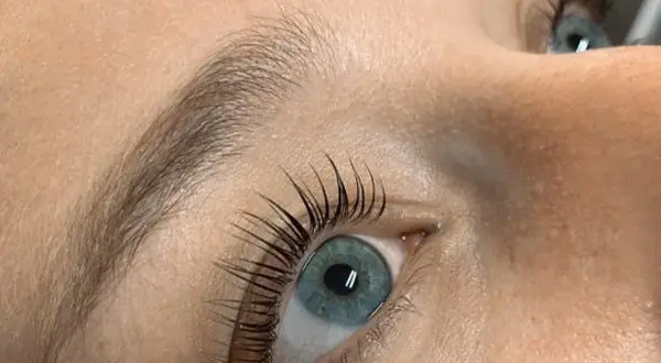 Oko z błękitną tęczówką i pięknie podkręconymi rzęsami po zabiegu Yumi Lashes.