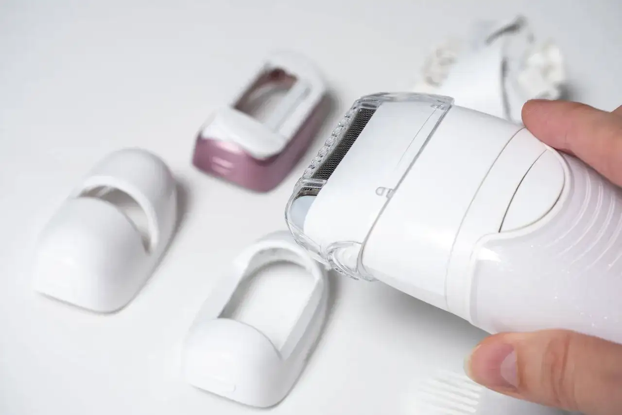 Dłoń trzyma depilator Philips Lumea, obok leżą różne nasadki. Dowiedz się, jak używać Philips Lumea.