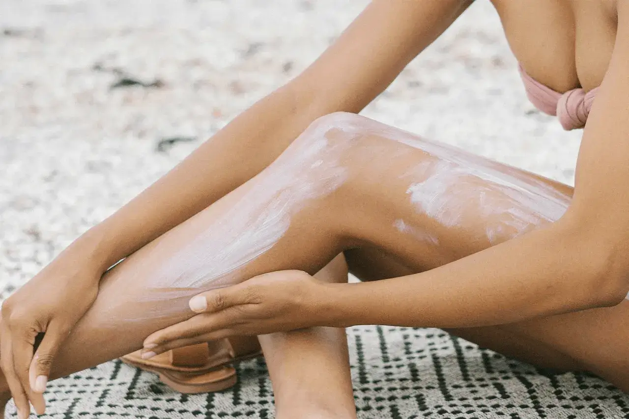kobieta wykonująca peeling n&oacute;g przed goleniem